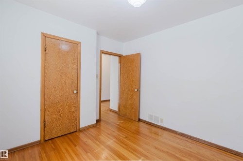 This room features hardwood flooring, white walls, and a ceiling light fixture - 11815 76 Avenue, Edmonton, AB - Indoor Photo Showing Other Room
