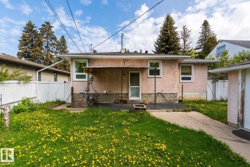The property features an exterior with a pink stucco finish and white trim windows - 11815 76 Avenue, Edmonton, AB - Outdoor