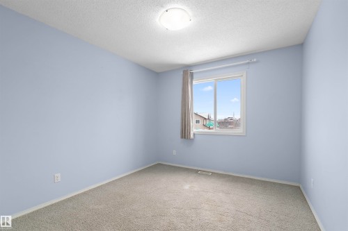 This room features light blue walls, gray carpeting, and a window with blinds - 11542 18A Avenue, Edmonton, AB - Indoor Photo Showing Other Room