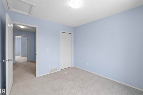 This room features light blue walls, a light-colored carpet, and a white bi-fold closet door - 11542 18A Avenue, Edmonton, AB - Indoor Photo Showing Other Room