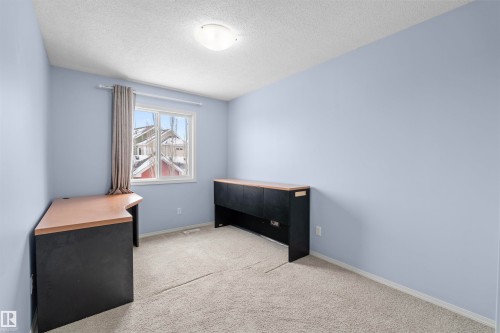 This room features light blue walls, a window with natural light, and carpeting - 11542 18A Avenue, Edmonton, AB - Indoor