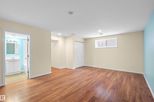 Spacious room featuring wood-look flooring, recessed lighting, and a window with blinds - 11542 18A Avenue, Edmonton, AB - Indoor