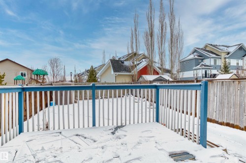 The property includes a deck with a blue and white railing, overlooking a fenced yard - 11542 18A Avenue, Edmonton, AB - Outdoor