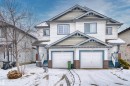 The property features a white exterior with blue trim, a two-car garage, and a covered front entrance - 11542 18A Avenue, Edmonton, AB  - Outdoor With Facade 