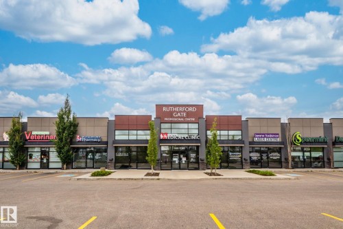 This commercial property features a storefront facade with large windows and signage for various businesses - 11542 18A Avenue, Edmonton, AB - Outdoor