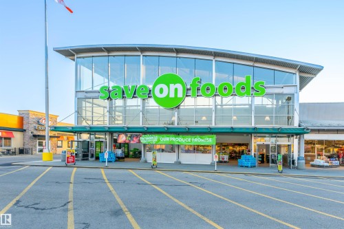 The property benefits from its proximity to a large grocery store with extensive glass frontage and a prominent green sign - 11542 18A Avenue, Edmonton, AB - Outdoor