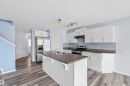 The property features a kitchen with white cabinetry, a kitchen island with an integrated sink, and stainless steel appliances - 11542 18A Avenue, Edmonton, AB  - Indoor Photo Showing Kitchen With Double Sink With Upgraded Kitchen 