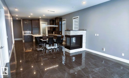 This property features a contemporary open-concept layout with dark, polished tile flooring throughout - 1781 Melrose Crescent, Edmonton, AB - Indoor Photo Showing Dining Room