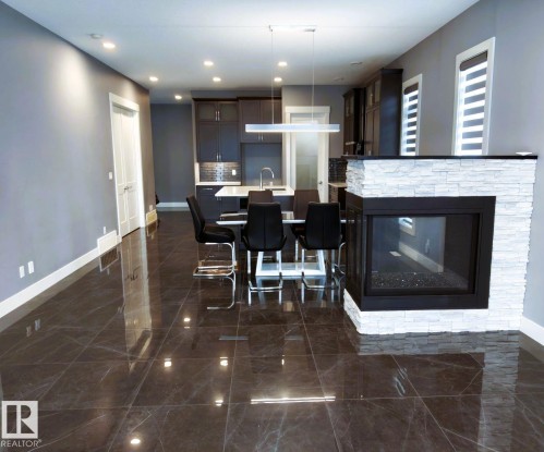 Living area with polished tiled flooring, a modern fireplace with a stacked stone facade, and recessed lighting - 1781 Melrose Crescent, Edmonton, AB - Indoor