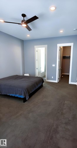 The property features a spacious room with light blue walls, recessed lighting, and a ceiling fan - 1781 Melrose Crescent, Edmonton, AB - Indoor Photo Showing Bedroom