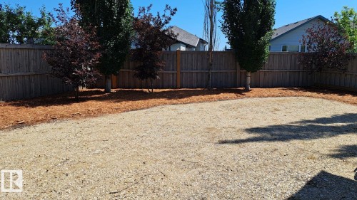 The property features a fenced yard with a gravel area and mature trees - 1781 Melrose Crescent, Edmonton, AB - Outdoor