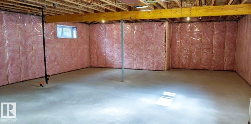The spacious, unfinished basement provides ample expansion potential, featuring exposed wooden ceiling joists, insulated walls, and a concrete floor - 1781 Melrose Crescent, Edmonton, AB - Indoor Photo Showing Basement