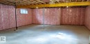 The spacious, unfinished basement provides ample expansion potential, featuring exposed wooden ceiling joists, insulated walls, and a concrete floor - 1781 Melrose Crescent, Edmonton, AB  - Indoor Photo Showing Basement 