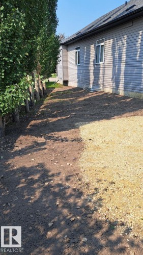 The property features light-colored horizontal siding, a dark roof, and white-trimmed windows - 1781 Melrose Crescent, Edmonton, AB - Outdoor