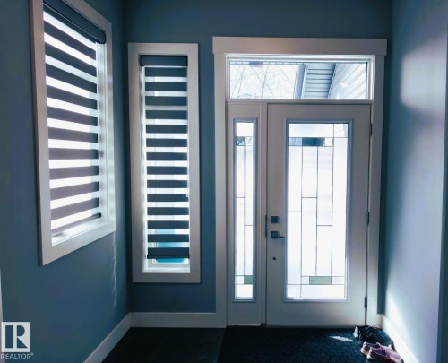Entryway featuring a white door with decorative glass panels, a transom window, and two side windows with horizontal blinds - 1781 Melrose Crescent, Edmonton, AB - Indoor Photo Showing Other Room