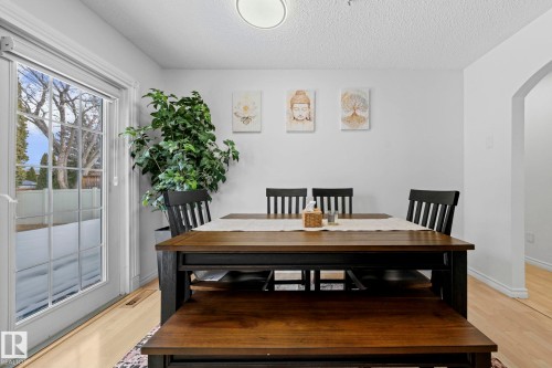 The dining area features light-toned flooring, a light-colored ceiling, and a glass-paned door that provides a view of the outdoors - 5418 17A Avenue, Edmonton, AB - Indoor Photo Showing Dining Room