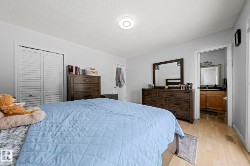 This room features light-colored walls, light wood flooring, and a ceiling light fixture - 5418 17A Avenue, Edmonton, AB - Indoor Photo Showing Bedroom