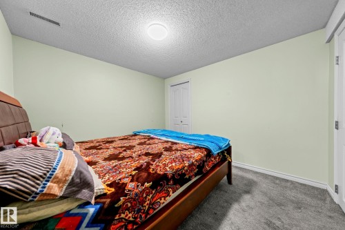 Room featuring light green walls, a white ceiling with a circular light fixture, and grey carpet flooring - 5418 17A Avenue, Edmonton, AB - Indoor Photo Showing Bedroom