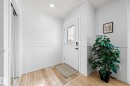 Entryway featuring light wood-look flooring, a white door with decorative glass inserts, and a closet with mirrored sliding doors - 5418 17A Avenue, Edmonton, AB  - Indoor Photo Showing Other Room 