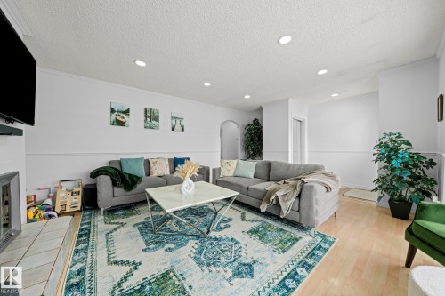 The living area features light-colored flooring, recessed lighting, and a white fireplace with a tiled hearth - 5418 17A Avenue, Edmonton, AB - Indoor Photo Showing Other Room