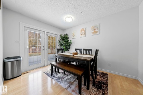 The dining area features light-toned hardwood flooring and a ceiling light fixture - 5418 17A Avenue, Edmonton, AB - Indoor Photo Showing Dining Room