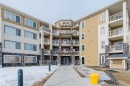 The property features a multi-story building with a light-colored exterior and stone accents - 402 3670 139 Avenue, Edmonton, AB  - Outdoor With Balcony With Facade 