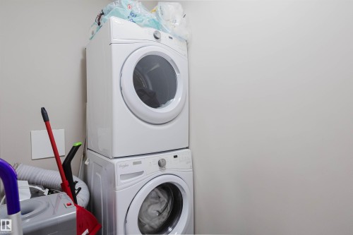 Laundry space featuring a stacked washer and dryer set - 402 3670 139 Avenue, Edmonton, AB - Indoor Photo Showing Laundry Room