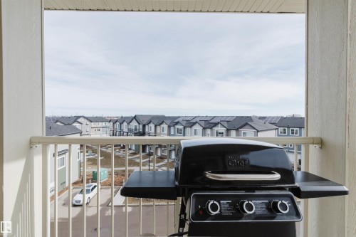 The property features a balcony with white railings, offering views of surrounding residences - 402 3670 139 Avenue, Edmonton, AB - 