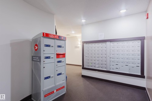 The property offers a dedicated mail area featuring individual mailboxes and a parcel locker system for convenience - 402 3670 139 Avenue, Edmonton, AB - Indoor Photo Showing Other Room