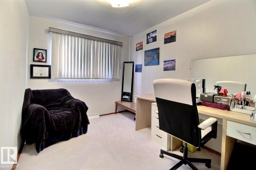 This room features light-colored carpeting, a window with vertical blinds, and a light fixture on the ceiling - 243 Lynnwood Way, Edmonton, AB - Indoor Photo Showing Office