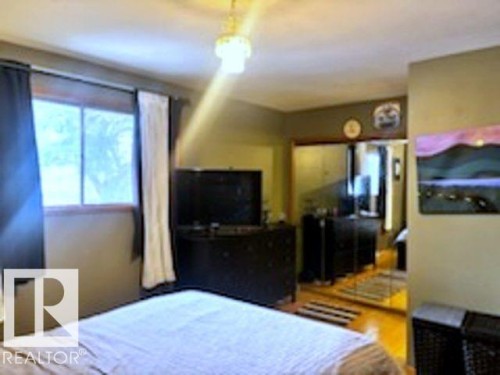 The bedroom features a window with dark and light curtains, a ceiling light fixture, and warm-toned walls - 243 Lynnwood Way, Edmonton, AB - Indoor