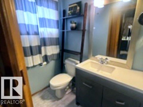 Bathroom featuring a vanity with an integrated sink, a mirror with an overhead light fixture, and a toilet - 243 Lynnwood Way, Edmonton, AB - Indoor Photo Showing Bathroom