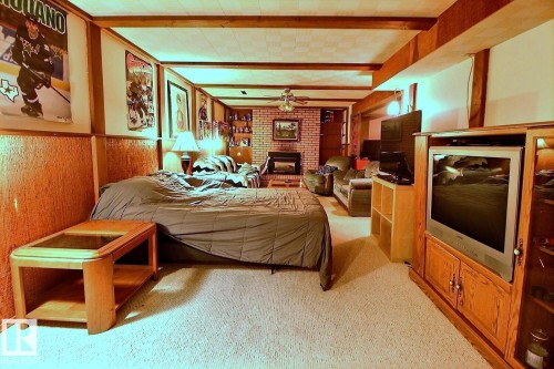 This spacious room features carpeted flooring, wood paneling, and exposed ceiling beams - 243 Lynnwood Way, Edmonton, AB - Indoor Photo Showing Bedroom