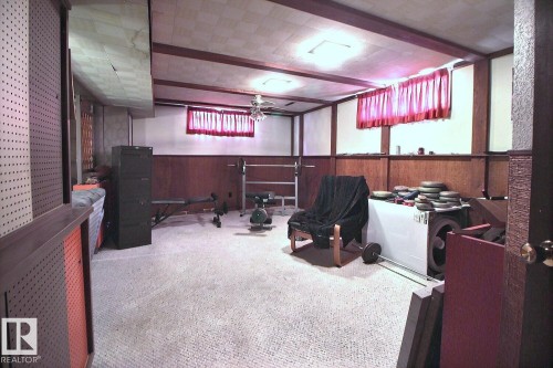 The property features a spacious room with wood paneling and exposed ceiling beams - 243 Lynnwood Way, Edmonton, AB - Indoor