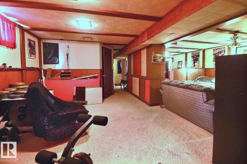 The property features a finished room with carpeted flooring, wood paneling, and ceiling lights - 243 Lynnwood Way, Edmonton, AB - Indoor
