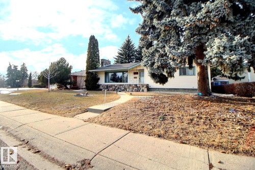 The property features a concrete walkway leading to the front entrance, a well-maintained lawn, and mature trees - 243 Lynnwood Way, Edmonton, AB - Outdoor