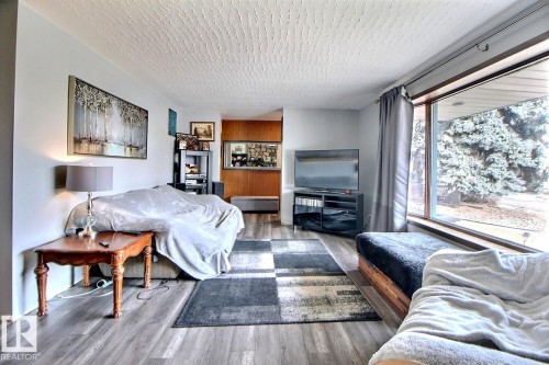 The living room features hardwood flooring and a large window offering views of outdoor trees - 243 Lynnwood Way, Edmonton, AB - Indoor