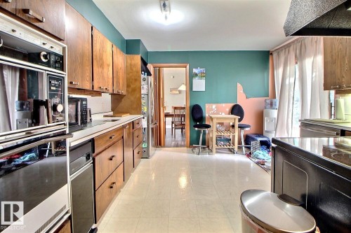The kitchen features extensive wood cabinetry, white countertops, and white flooring - 243 Lynnwood Way, Edmonton, AB - Indoor Photo Showing Kitchen With Double Sink