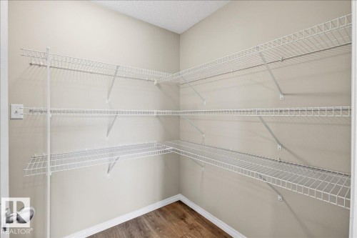 This spacious storage area features extensive white wire shelving, light-colored walls, and wood-look flooring - 17023 38 Street Nw, Edmonton, AB 