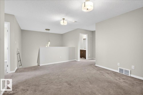 Upstairs bonus room, private area for the family. This versatile space features carpeting, neutral wall tones, and recessed lighting - 17023 38 Street Nw, Edmonton, AB 