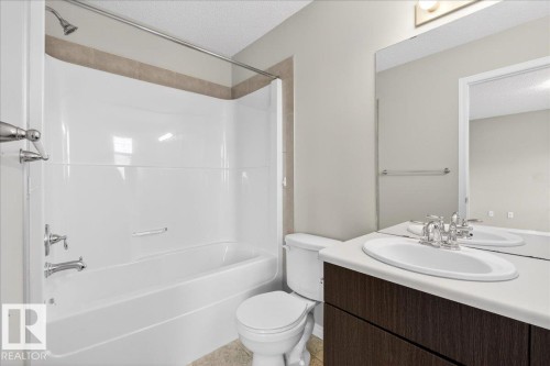 The bathroom features a white tub and shower combination with a curved shower rod - 17023 38 Street Nw, Edmonton, AB 
