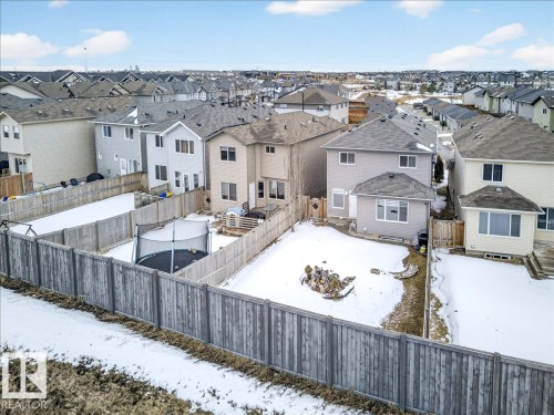 The property features a fenced yard with a patio area and a detached structure with a window - 17023 38 Street Nw, Edmonton, AB 