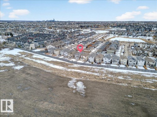 Aerial view of the property and its surrounding neighborhood, showcasing a residential area with various housing styles and a distant skyline - 17023 38 Street Nw, Edmonton, AB 