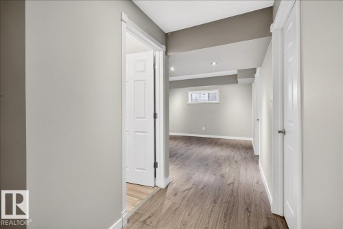 Spacious interior featuring light-colored walls, wood-style flooring, and recessed lighting - 17023 38 Street Nw, Edmonton, AB - Indoor Photo Showing Other Room