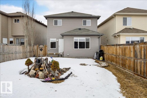 The property features a two-story exterior with grey siding and a fenced yard with a rock garden - 17023 38 Street Nw, Edmonton, AB - Outdoor With Exterior