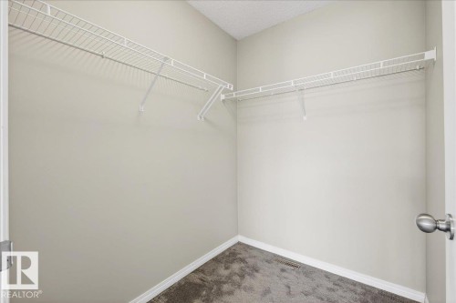 The property features a walk-in closet with white wire shelving and grey carpet - 17023 38 Street Nw, Edmonton, AB - Indoor With Storage