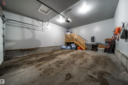 This garage features a concrete floor, painted walls, and overhead lighting - 3514 49 Avenue, Beaumont, AB - Indoor Photo Showing Garage