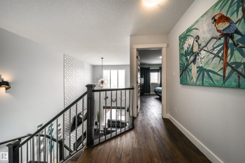 The property features rich dark wood flooring and a staircase with black railings - 3514 49 Avenue, Beaumont, AB - Indoor Photo Showing Other Room
