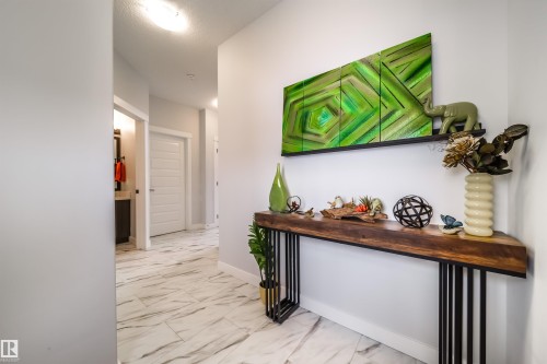 The property features a hallway with white walls and light-toned, patterned floor tiles - 3514 49 Avenue, Beaumont, AB - Indoor Photo Showing Other Room
