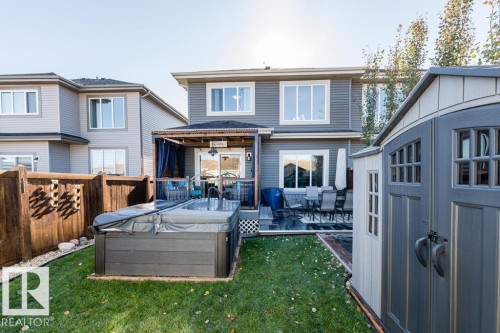 The property features a well-maintained lawn, a hot tub, and a shed - 3514 49 Avenue, Beaumont, AB - Outdoor